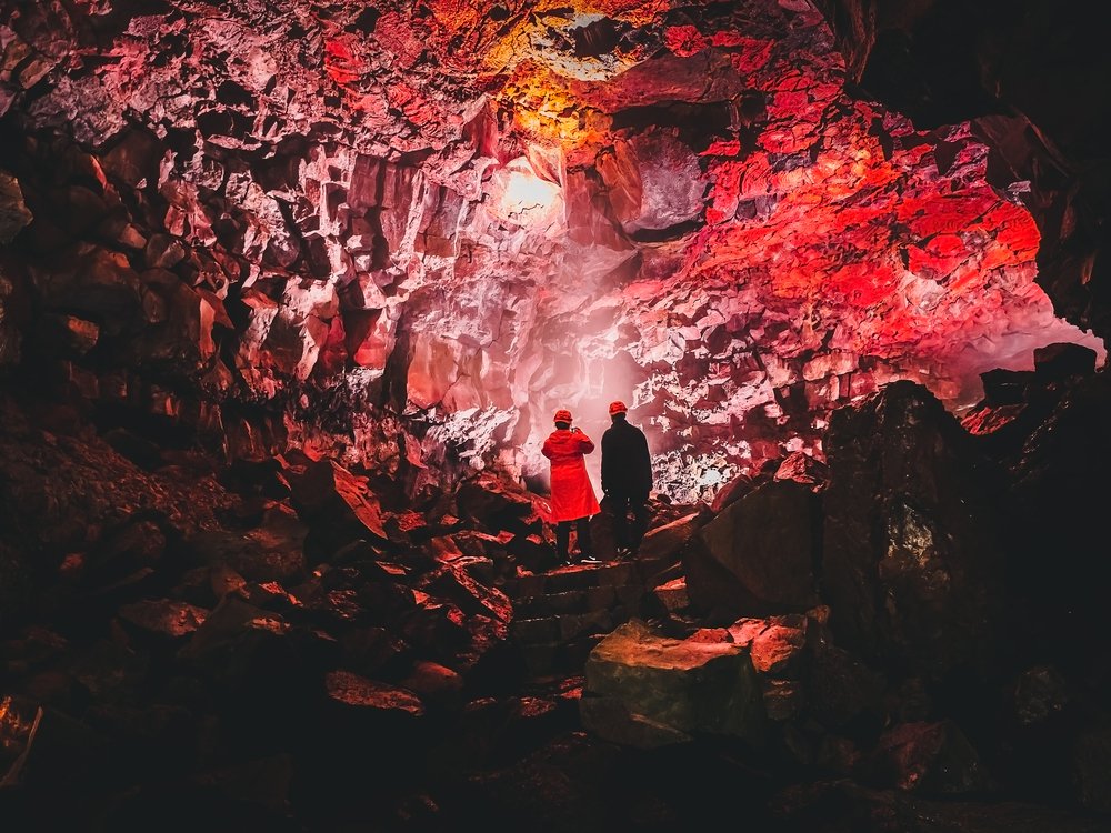 Pareja en medio de un tunel de una cueva de lava en Reykjavik