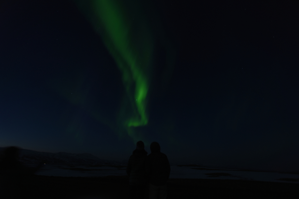 Pareja viendo juntos la aurora boreal, uno de los planes más románticos en Islandia