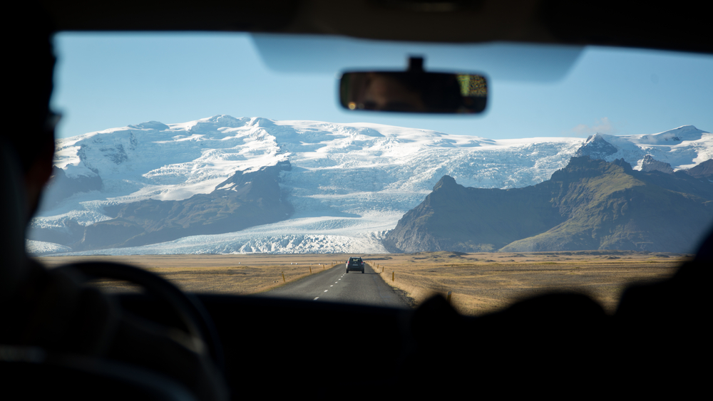 Hombre en coche de alquiler para conducir por Islandia
