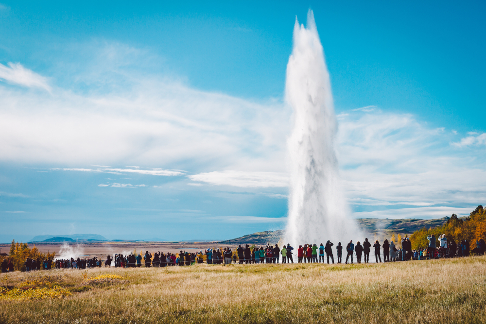 Grupo de turistas guiados a geysir como forma de turismo responsable en Islandia
