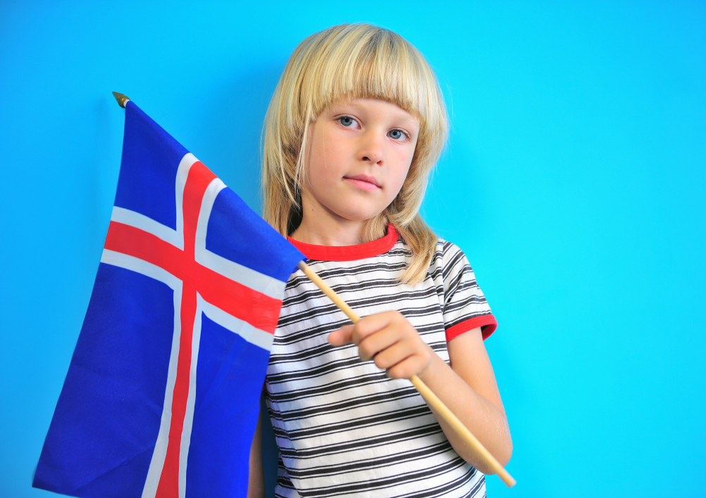 Pequeña niña islandesa con la bandera de su país, un lugar ideal para familias