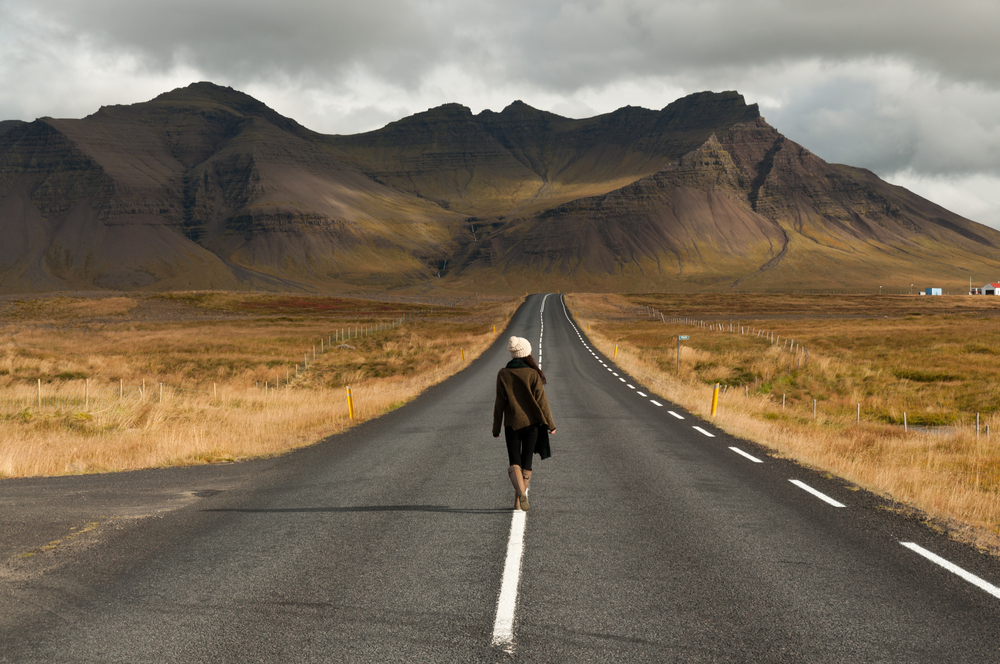 Chica caminando por una de las carreteras más pintorescas de Islandia en Snaefellsnes